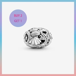 Könnte beinhalten: Ein silberner Charm-Anhänger mit einem detaillierten Design aus Muscheln und einem Seestern. Der Charm hat eine runde Form mit einem Loch an jedem Ende. Der Text "BUY 2 GET 1" befindet sich in einem lila Kreis oben links.