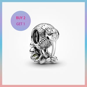 May include: A silver kiwi bird charm with detailed feathering and a long beak. The charm is set against a white background with a purple circle that reads "BUY 2 GET 1".