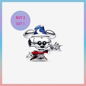 Puede incluir: Un charm de plata con un personaje de dibujos animados con una túnica roja y un sombrero de mago azul con una luna creciente y estrellas. El charm sostiene una varita en forma de estrella con una gema transparente. Un círculo morado con el texto "BUY 2 GET 1" está en el fondo.