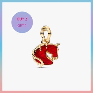 May include: A gold-coloured charm featuring a red horse head design. The horse head is outlined in gold and has a glossy finish. The charm has a loop for attaching to a bracelet or necklace. A purple circle with the text "BUY 2 GET 1" is in the background.