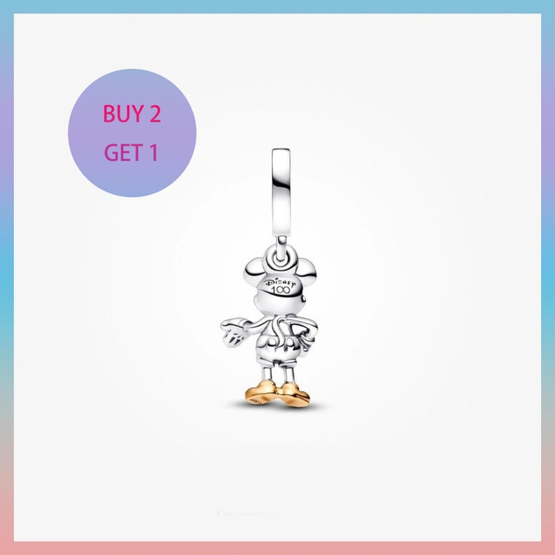 May include: A silver Mickey Mouse charm with gold-colored shoes and accents. The charm has a loop at the top for attachment and features the text "Disney 100". A purple circle with the text "BUY 2 GET 1" is in the upper left corner.