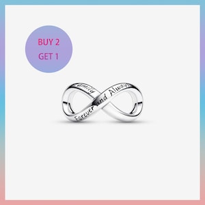 May include: A silver-colored infinity charm with the words "Family Forever and Always" engraved on it. The charm is in the shape of the infinity symbol. A purple circle with the text "BUY 2 GET 1" is in the upper left corner.