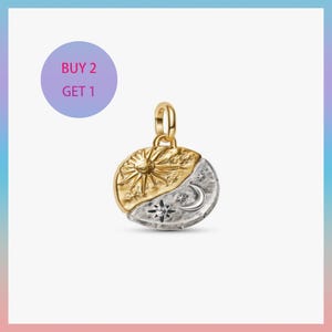 May include: A gold and silver pendant featuring a sun and moon design. The sun is gold, and the moon is silver with stars and a crescent. The pendant has a loop for a chain. The image also includes a "BUY 2 GET 1" promotion.