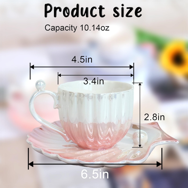 May include: A two-tone teacup and saucer set. The cup is white on top and pink on the bottom, with a pearl accent on the handle. The saucer is shell-shaped and pink. The cup is 4.5 inches wide, 3.4 inches in diameter, and 2.8 inches tall. The saucer is 6.5 inches wide. Capacity is 10.14oz.