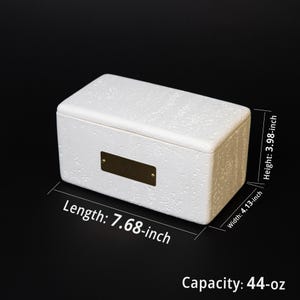 May include: A white rectangular box with a textured surface and a small, rectangular brass plate. The box measures 7.68 inches in length, 4.13 inches in width, and 3.98 inches in height, with a capacity of 44 ounces.