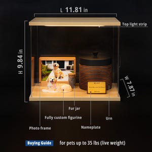 May include: A pet memorial display case with a wooden frame, measuring 11.81 inches long, 9.84 inches high, and 7.87 inches wide. It includes a photo frame, a figurine, a fur jar, and an urn. The display has a top light strip and a nameplate.