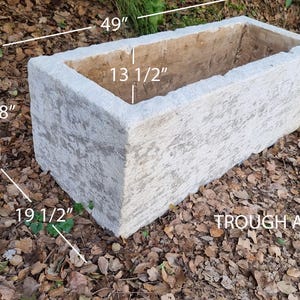 Puede incluir: Abrevadero rectangular de hormigón, 124 cm de largo, 46 cm de alto y 50 cm de ancho. El interior mide 34 cm de ancho. El abrevadero es de color gris claro con una superficie texturizada. El texto "TROUGH A" es visible.