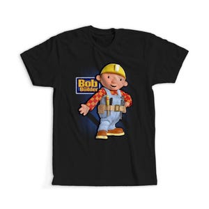 Peut inclure: T-shirt noir avec une image de dessin animé de Bob le Bricoleur. Le personnage porte un casque jaune, une salopette bleue et une ceinture à outils. Le logo Bob le Bricoleur est dans un rectangle bleu.