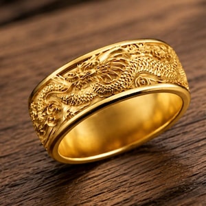 Pu&ograve; includere: Un anello color oro caratterizzato da un rilievo dettagliato di un drago che avvolge l'intera fascia esterna. La superficie dell'anello presenta una finitura metallica lucida con squame complesse e tratti del volto visibili sul drago.