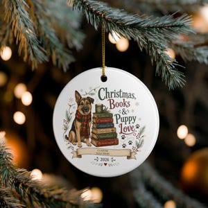 Può includere: Un ornamento rotondo in ceramica bianca raffigurante un pastore tedesco con una sciarpa a quadri rossi e verdi accanto a una pila di libri sormontata da una tazza. Il testo recita Christmas, Books & Puppy Love, Custom Text Here e 2026 con impronte.