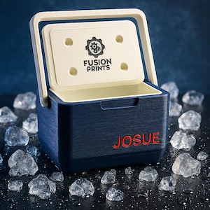 May include: A navy blue cooler with a white interior and lid. The lid features the text "FUSION PRINTS" and a gear logo. The name "JOSUE" is printed in red on the front of the cooler. Ice cubes surround the cooler.