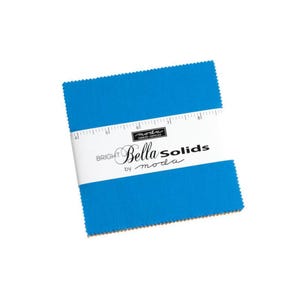 Puede incluir: Una pila de cuadrados de tela azul brillante con una banda blanca con el texto "BRIGHT Bella Solids by moda". Los cuadrados de tela tienen un borde festoneado y una regla impresa en la banda blanca.