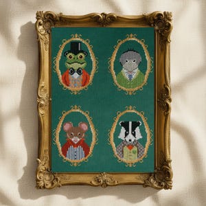 May include: A framed cross-stitch artwork featuring four anthropomorphic animals in oval frames against a green background. The animals include a frog, a dog, a mouse, and a badger, each wearing formal attire. The frame is ornate and gold-colored.