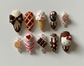 May include: Ten artificial nails with dessert-themed designs. The nails feature a pie, ice cream cones, a chocolate bar, a cat, and a Hello Kitty face. The designs are in vibrant colours, perfect for a fun and unique manicure.