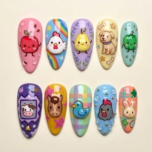 May include: A set of ten almond-shaped press-on nails featuring colorful 3D designs including a red apple, a chicken with a rainbow, a yellow pear, a puppy, a green pepper, a cow, a horse, a blue duck, a chicken, and a rabbit.