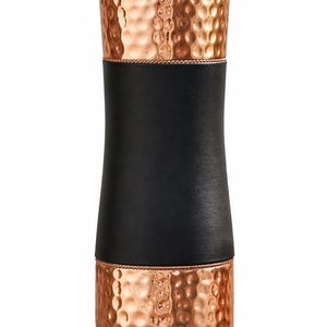 May include: A copper-coloured water bottle with a hammered texture. The bottle has a black leather band around the middle. The top and bottom sections are copper, and the lid is also copper-coloured.