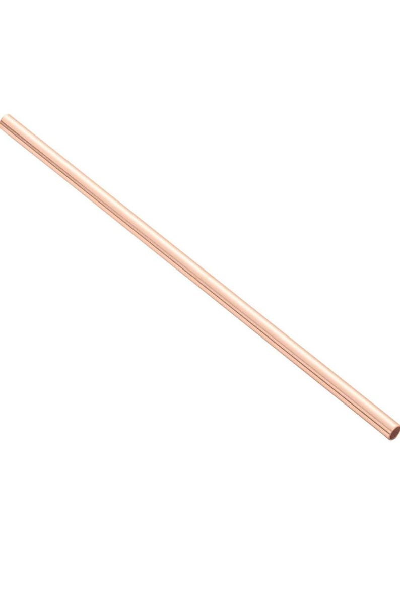 May include: A single, straight copper tube, angled diagonally across a white background. The tube has a smooth, polished surface and a consistent diameter. The color is a warm, reddish-brown.