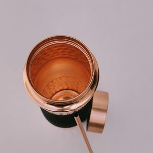 May include: A copper-colored tumbler with a matching lid and straw. The interior of the tumbler has a textured surface. The tumbler is set against a white background.