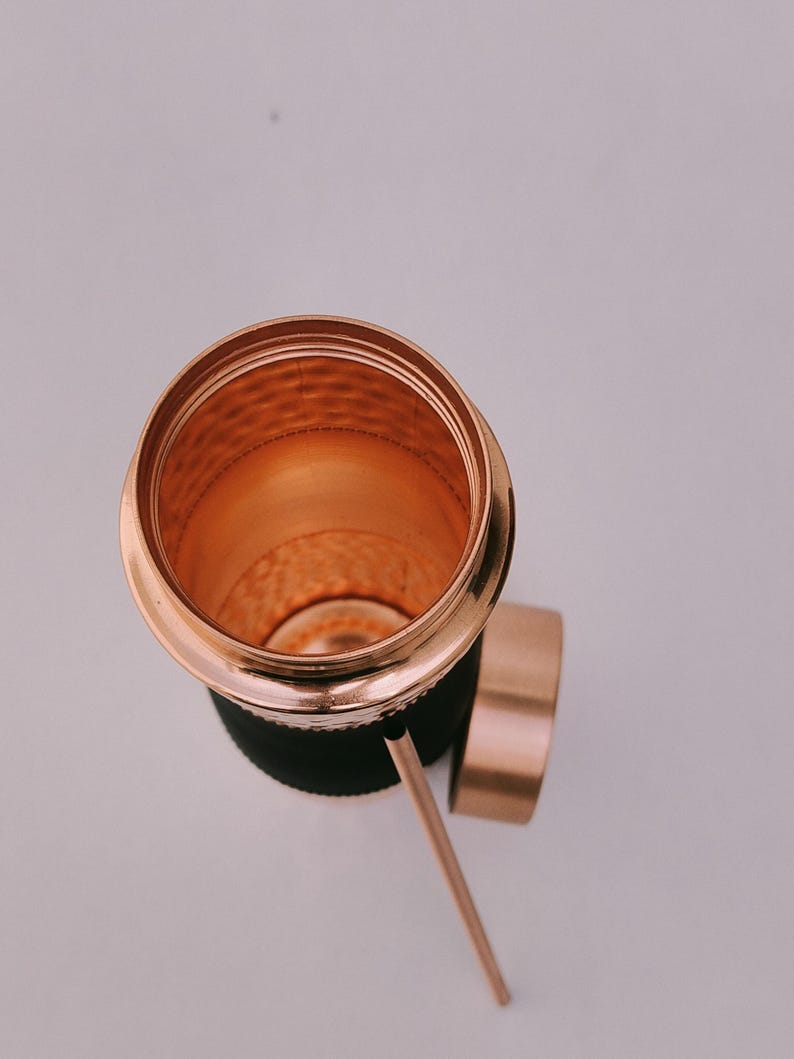May include: A copper-colored tumbler with a matching lid and straw. The interior of the tumbler has a textured surface. The tumbler is set against a white background.