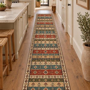 Può includere: Un lungo tappeto passatoia rettangolare caratterizzato da un motivo ripetitivo di fasce orizzontali nei toni del rosso, verde acqua, verde e beige. Il design include forme geometriche e motivi floreali stilizzati, con un bordo marrone scuro.