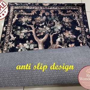 Puede incluir: Una alfombra rectangular con un fondo azul oscuro y un dise&ntilde;o detallado de &aacute;rbol y flores. La alfombra tiene un borde adornado. La parte inferior es gris con un patr&oacute;n geom&eacute;trico, y el texto "anti slip design" es visible.