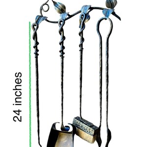 May include: Hand-forged fireplace tool set, 24 inches tall and 16 inches wide, featuring a poker, shovel, brush, and a log lifter. The set has a decorative bird and leaf design with blue and gold accents. The tools are made of dark metal.