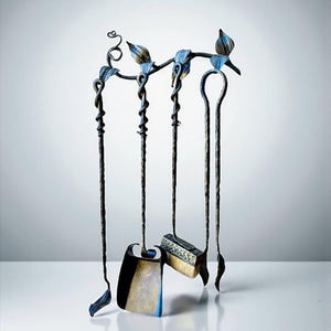 May include: A decorative fireplace tool set with a black and blue finish. The set includes a poker, brush, shovel, and a stand with leaf and vine accents. The tools hang from a horizontal bar with stylized leaf and vine details.