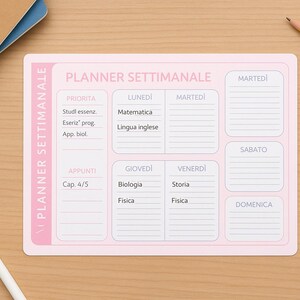 Puede incluir: Un planificador semanal rosa con el texto "PLANNER SETTIMANALE" y secciones diarias para notas. Un bolígrafo, un lápiz y una goma de borrar están sobre una superficie de madera.