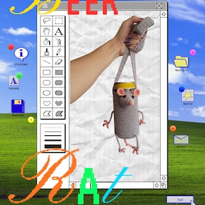 May include: A gray crocheted beer can cozy shaped like a mouse, with pink ears and feet, held by a gray strap. The image has the words "Beer Rat Mudra" in colorful text, set against a Windows XP-style background.