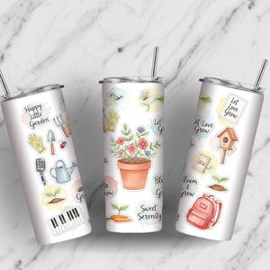 Puede incluir: Tres vasos de acero inoxidable con pegatinas con temática de jardinería. Cada vaso tiene una pajita plateada y un fondo blanco. Las pegatinas incluyen herramientas de jardinería, flores y las frases "Happy Little Garden", "Let Love Grow" y "Sweet Serenity".