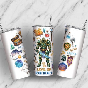 May include: Three white stainless steel tumblers with fantasy-themed illustrations. One features a treasure chest, another a knight, and the third a lion crest. Each has a silver straw and the text "LEVEL UP RAID READY".