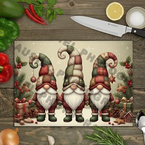 Puede incluir: Tabla de cortar rectangular con tres gnomos navideños. Los gnomos tienen largas barbas blancas, narices rojas y sombreros de patchwork en tonos verdes, rojos y marrones. Decoraciones festivas, estrellas y regalos rodean a los gnomos.