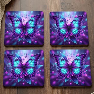 May include: Set of four square coasters featuring a vibrant butterfly design. The butterflies have purple and turquoise wings with intricate details, set against a purple and blue background. Decorative coasters for home decor.