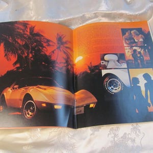 May include: Open magazine spread featuring a vintage sports car, palm trees, and a sunset. The car is a light color with black wheels. The background has a warm orange and red color palette. Additional images are on the right page.