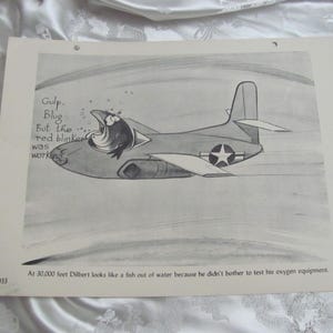 May include: A black and white cartoon illustration of a jet airplane with a fish in the cockpit. Text bubbles read "Gulp. Blug. But the red blinker was working." The text at the bottom reads "At 30,000 feet Dilbert looks like a fish out of water..."