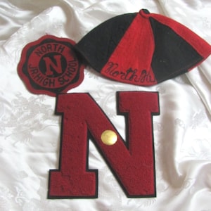 May include: A red and black felt beanie with the word North embroidered on the front, a circular patch reading North Jr. High School, and a large red letter N patch with a black border and a small gold circular pin attached to the center.