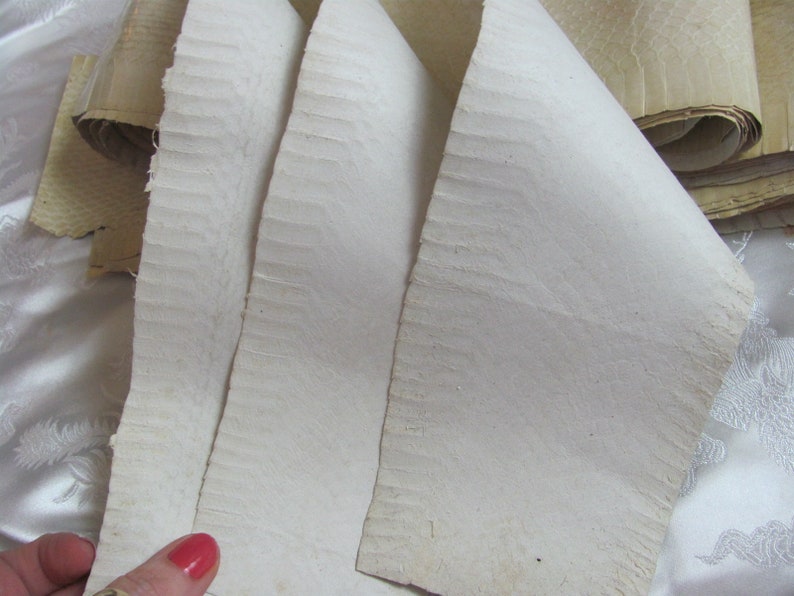 May include: Four sheets of white, textured paper, folded and stacked on top of each other. The paper has a slightly rough, uneven surface.