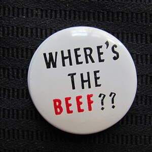 May include: A white button with black text that reads "Where's the beef?" The word "beef" is in red.