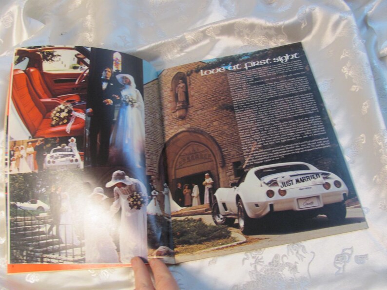 May include: A magazine spread featuring wedding photos and a white Corvette. The car has a "Just Married" sign on the back. The interior of the car is red. The text "love at first sight" is visible.