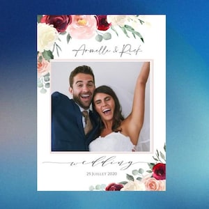 Peut inclure: Carte photo de mariage avec un couple souriant. La carte est ornée de fleurs rouges, roses et blanches. Les noms "Armelle & Rick" sont écrits au-dessus de la photo, avec "wedding" et la date "25 JUILLET 2020" en dessous.