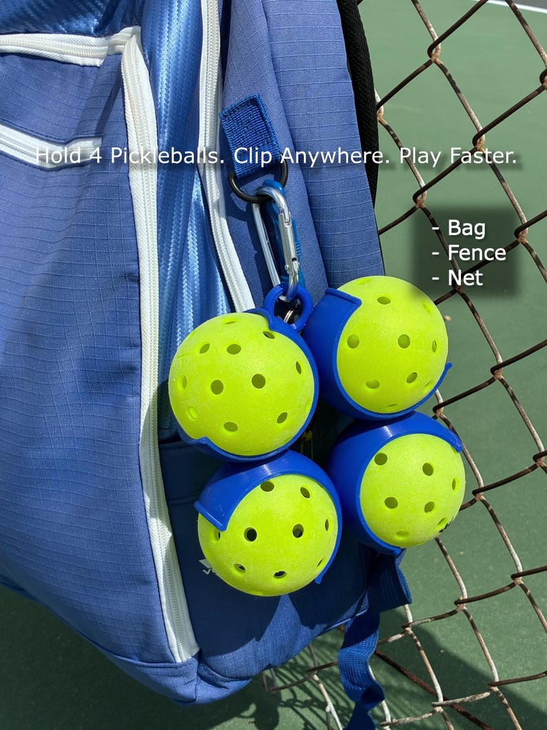 May include: A blue backpack with a silver carabiner clip holding four pickleballs. The pickleballs are yellow with blue holders. Text on the image reads: "Hold 4 Pickleballs. Clip Anywhere. Play Faster."