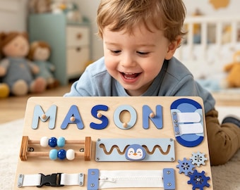 May include: A wooden activity board with the name "MASON" in blue letters. The board includes interactive elements such as a zipper, gears, a penguin, and a bead maze. Designed for toddlers and young children, it promotes fine motor skills.