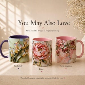K&ouml;nnte beinhalten: Drei Keramikbecher mit floralen Designs. Einer zeigt Calla-Lilien, ein anderer eine Pfingstrose und der dritte Rosen. Die Becher haben farbige Innenr&auml;ume und Henkel. Auf den Bechern steht "Calla Lily", "Peony" und "Rose Elegance". Der Text "You May Also Love" steht oben.