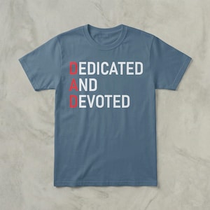 May include: A blue t-shirt with the words "DEDICATED AND DEVOTED" printed on the front. The letters "D" and "D" are red, while the rest of the text is white. The shirt has a crew neck and short sleeves.