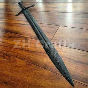 Puede incluir: Una espada de doble filo con una hoja de acero de Damasco oscuro y estampado con un grano ondulado visible. La espada tiene una guarda recta y un mango oscuro y texturizado. El texto ZH Crafts está superpuesto en el centro de la hoja.