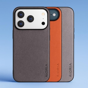 May include: Three mobile phone cases in a row, each with a different colour and texture. The first case is dark grey, the second is orange, and the third is light grey. The brand name "AIORIA" is printed vertically on each case.