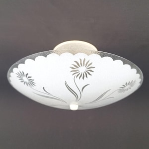 May include: A white, scalloped-edge ceiling light fixture with a floral design. The glass shade features etched flowers and stems in a gray color. The fixture is mounted on a circular, off-white base.