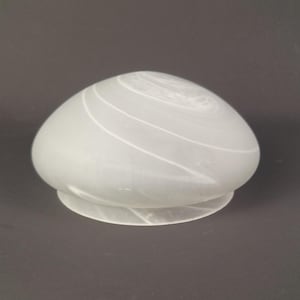 May include: A dome-shaped glass light shade with a frosted, semi-translucent white finish. The surface features subtle, swirling opaque white patterns that wrap around the rounded form, ending in a circular base opening.