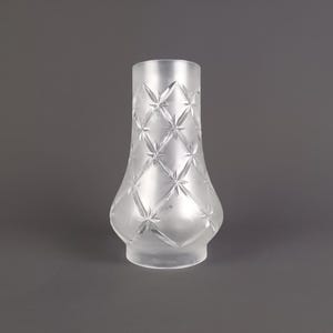 Puede incluir: Una pantalla de lámpara de vidrio transparente y esmerilado con un patrón de diamantes de diseños de estrellas. La pantalla tiene una base redondeada y una parte superior cilíndrica, adecuada para una lámpara o luminaria.