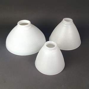 May include: A set of three ceramic mugs with a speckled, matte finish. The mugs are in shades of cream, light gray, and dark gray. Each mug has a simple, minimalist design and a rounded handle.